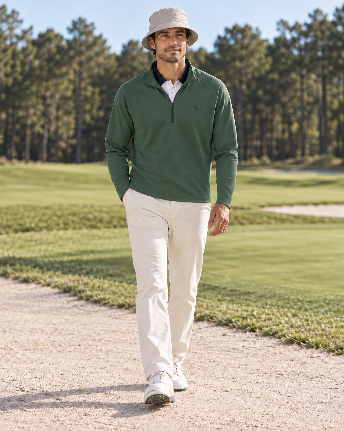 Model wearing a Forest Green Range Zip over a White Hickory Polo, with a Stone Fairway Bucket. The plain ivory trousers and shoes are styling only.